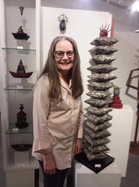 <p>Linda Korstad in front of her quirky, fun ceramic art.
</p>