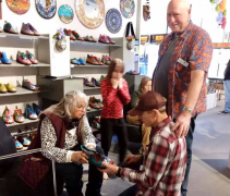 <p>Our shoemaker, Mark Carter, fitting Peggy with her new shoes while father-in-law, John looks on. Granddaughter Zoe in perpetual motion!</p>
