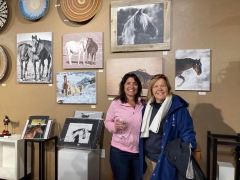 <p>Jody Miller in front of her equine photography with wife, Christy Garavetto.</p>
