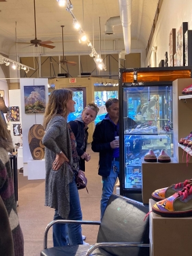 <p>Our jeweler, Chelsea Stone (front) discussing her jewelry in her case as well as what she was wearing</p>